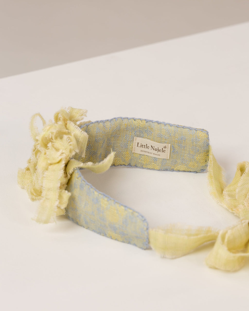 Floral tie-back headband with a flowers from fabric scraps on a white surface
