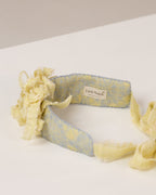 Floral tie-back headband with a flowers from fabric scraps on a white surface