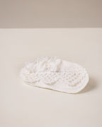 White linen hair clip with crocheted lace on a beige background