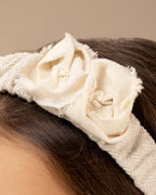 Close-up of a girl wearing a decorative linen headband with linen flowers on a neutral background